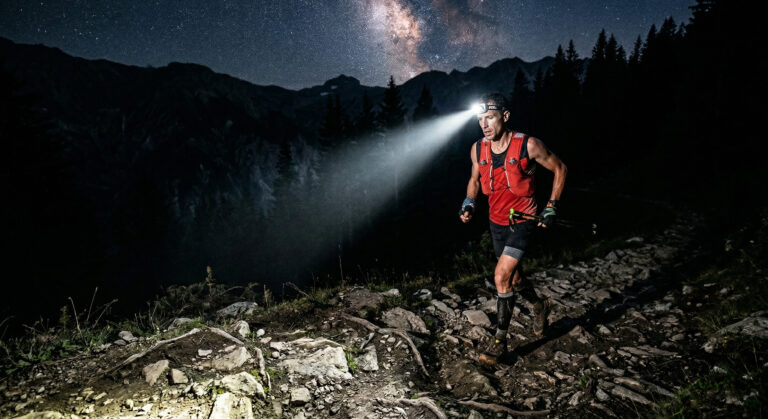 Coureur d'ultratrail dans la nuit, seul avec le faisceau de sa lampe frontale